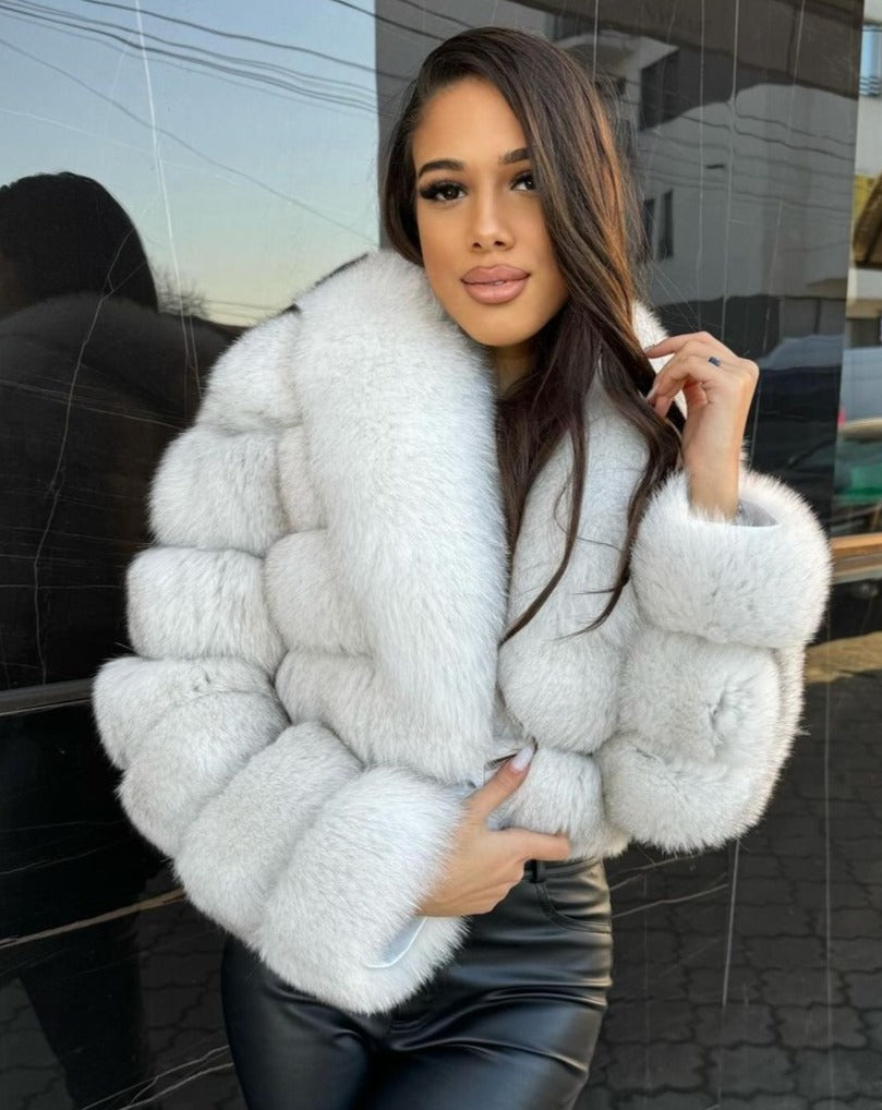 Chic model showcasing the Giselle white fox fur jacket, embodying elegance and luxury in her attire.