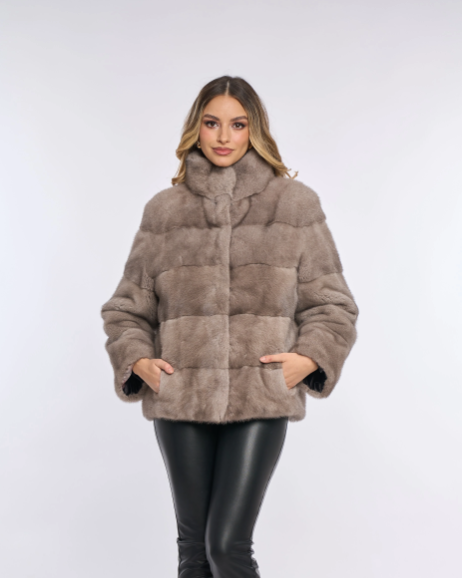 A model wearing a grey mink coat with a visually textured surface, paired with black leather pants.